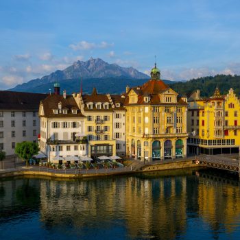 The colorful buildings near a river surrounded by mountains in Lucerne in Switzerland